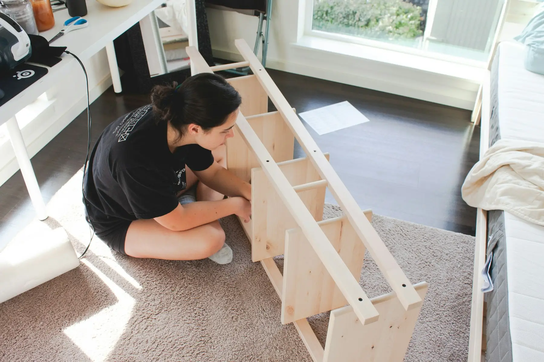 Una persona montando un mueble de madera en el suelo de su casa